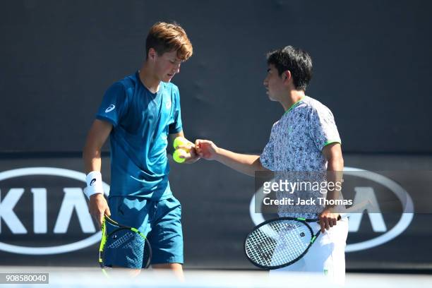 Naoki Tajima of Japan and Alexey Zakharov of Russia compete in their boy's doubles match against Rinky Hijikata of Australia and Taisei Ichikawa of...