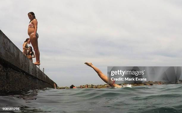 Girls jump into the ocean at Clovelly on January 22, 2018 in Sydney, Australia. Sydney's CBD reached a top of 33 degrees Celcius today, while...