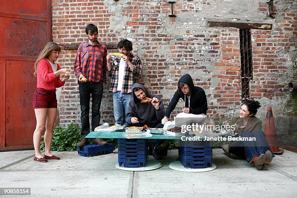 Brooklyn-based music group Dirty Projectors eat food on a makeshift, sidewalk table, Brooklyn, New York, June 2009. Pictured are, from left, Amber...