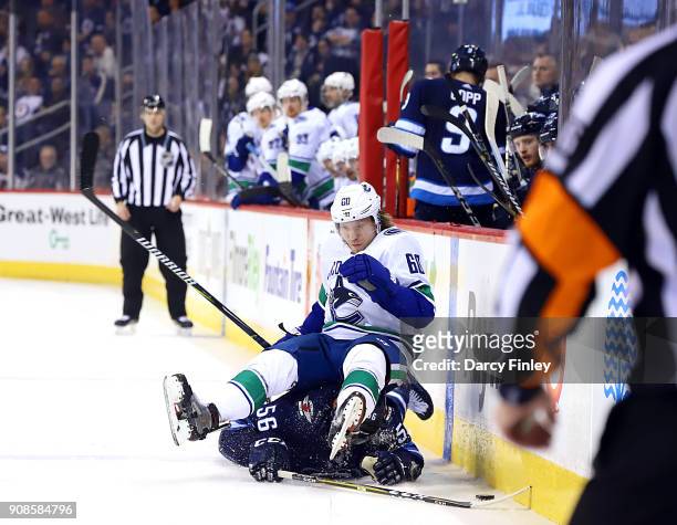 Markus Granlund of the Vancouver Canucks falls on top of Marko Dano of the Winnipeg Jets after a battle for the puck during third period action at...