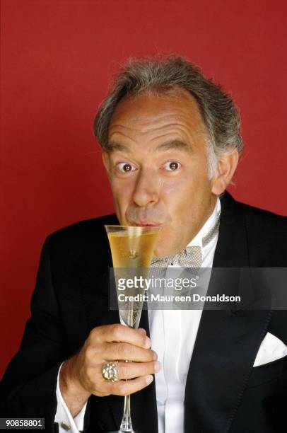 English celebrity writer Robin Leach sips a glass of champagne, circa 1990. He hosted the television show 'Lifestyles of the Rich and Famous' in the...