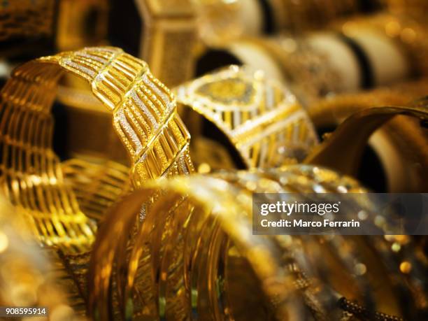 gold bracelets for sale at gold souk in dubai, united arab emirates - dubai shopping stock pictures, royalty-free photos & images