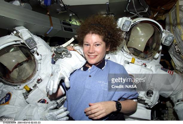 Astronaut Susan J. Helms, STS-102 mission specialist, is pictured March 10, 2001 on the mid deck with both Extravehicular Mobility Unit space suits...