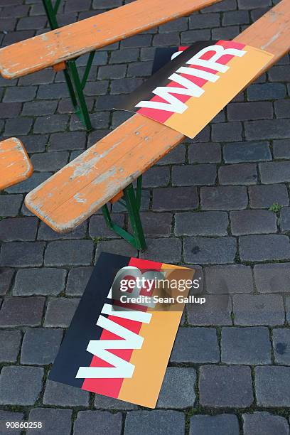 Signs that read: "Us" on a German flag lie on benches after an election campaign rally attended by Chancellor and German Christian Democratic Union...