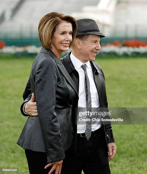 Musician Paul Simon , co-founder of the Children's Health Fund, and Speaker of the House Nancy Pelosi pose for photographs after an event to...