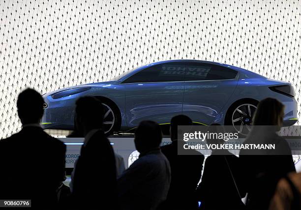 Trade fair visitors and journalists look at the Renault Fluence ZE electric car during the 63rd International Motor Show in the central German city...