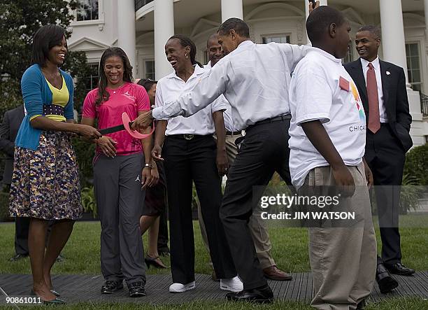 President Barack Obama pretends to fence with First Lady Michelle Obama during an event on Olympics, Paralympics and youth sport on the South Lawn of...