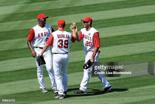 Gary Matthews Jr. #24, Robb Quinlan and Juan Rivera of the Los Angeles Angels of Anaheim celebrate defeating the Oakland Athletics 9-1 on August 30,...
