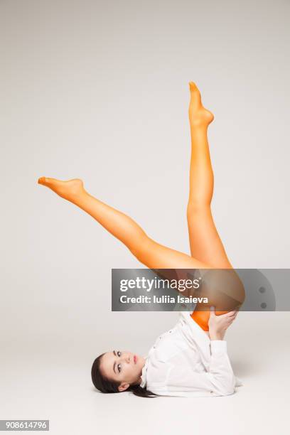 woman in orange tights keeping legs up - legs in nylon fotografías e imágenes de stock