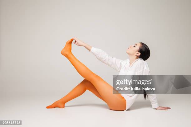 woman in orange tights pointing toes - women wearing nylons photos et images de collection