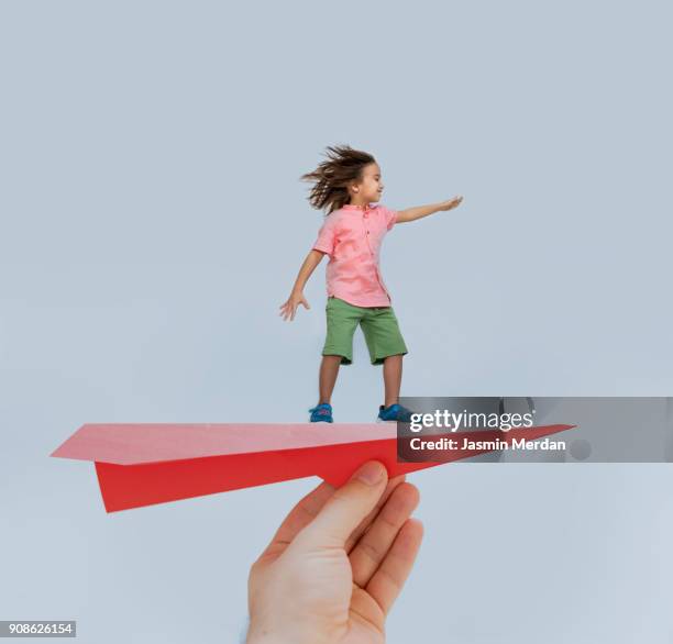 the boy is enjoying his flying on paper plane in father's hand - kid pilot stock pictures, royalty-free photos & images