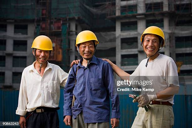 three male construction workers with helmets outdoors smiling - dirty construction worker stock pictures, royalty-free photos & images