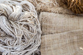 Natural color threat on blurred hessian fabric