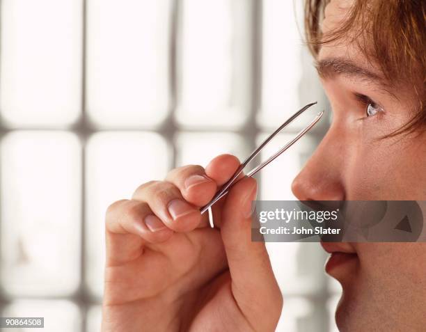 man plucking eyebrows - man plucking eyebrows stock pictures, royalty-free photos & images