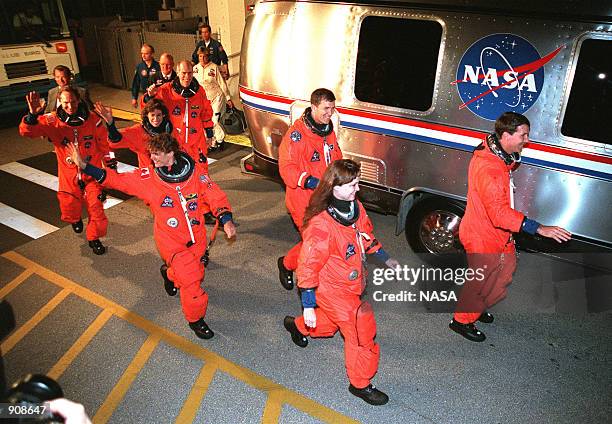 The STS-96 crew smile and wave at onlookers as they eagerly head for the liftoff of Space Shuttle Discovery May 27, 1999 at Kennedy Space Center,...