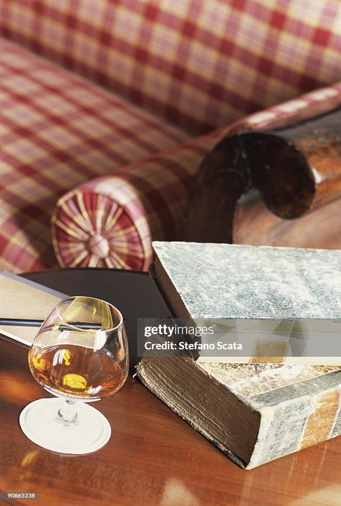 Glass of cognac and books