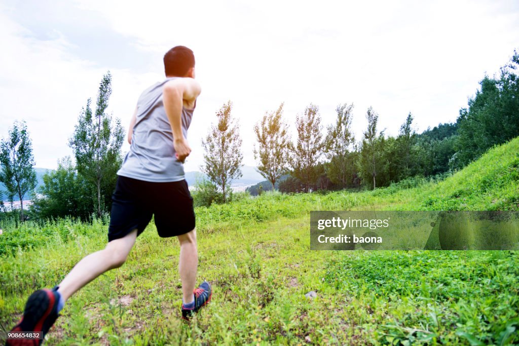 Young man running on grass