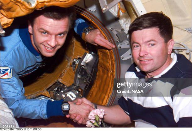 Following the successful in-space docking of Russias Mir Space Station and the Space Shuttle Atlantis, astronaut Kenneth D. Cameron, right, shakes...