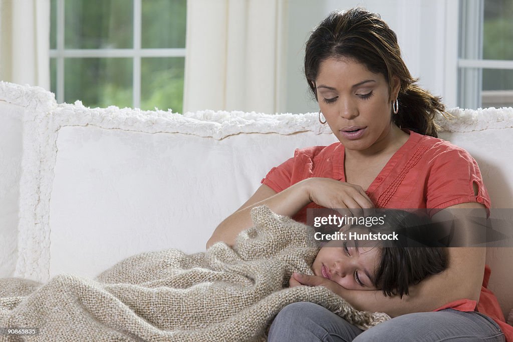 Hispanic girl lying on her mother's lap