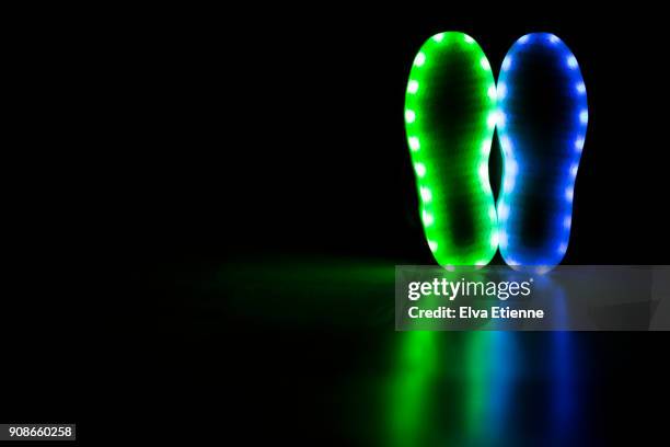 glowing soles of a pair of led lit shoes - sole of shoe stock-fotos und bilder