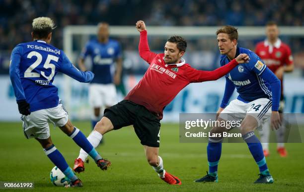 Amine Harit of Schalke and Bastian Oczipka of Schalke challenge Julian Korb of Hannover during the Bundesliga match between FC Schalke 04 and...