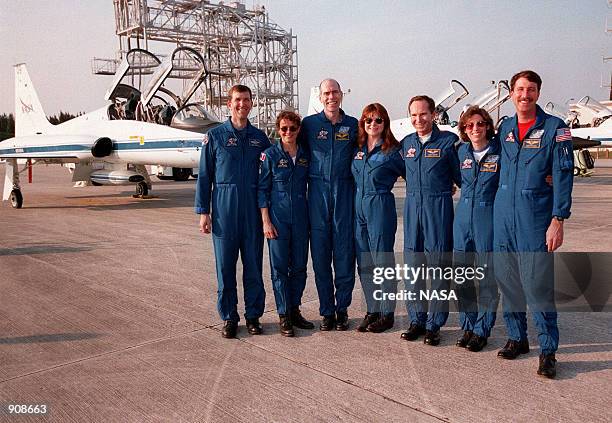 After arriving at Kennedy on the T-38 jet aircraft in the background, the STS-96 crew pose for photographers at the Shuttle Landing Facility. From...