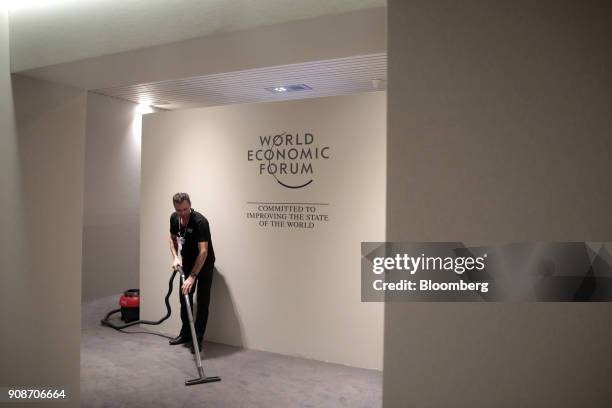 Worker hoovers the carpet inside the Congress Center during preparations ahead of the World Economic Forum in Davos, Switzerland, on Monday, Jan. 22,...