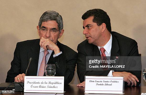 Costa Rican President Oscar Arias listens to Honduran Liberal Party presidential candidate, Elvin Ernesto Santos, during a press conference also...