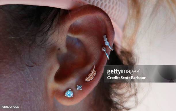 Detail of the ear piercings of Madison Keys of the United States are seen in her fourth round match against Caroline Garcia of France on day eight of...