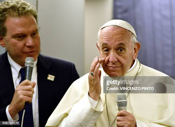 Pope Francis answers journalists flanked by the director of the Vatican press office Greg Burke during a press conference on board of the plane...