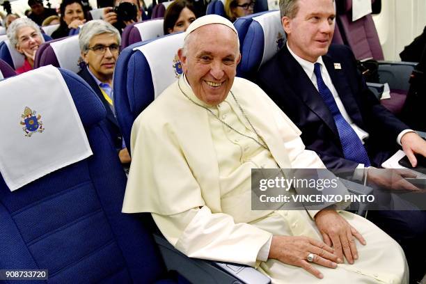 Pope Francis smiles next to director of the Vatican press office Greg Burke , during a pause in the press conference on board of the plane on his...