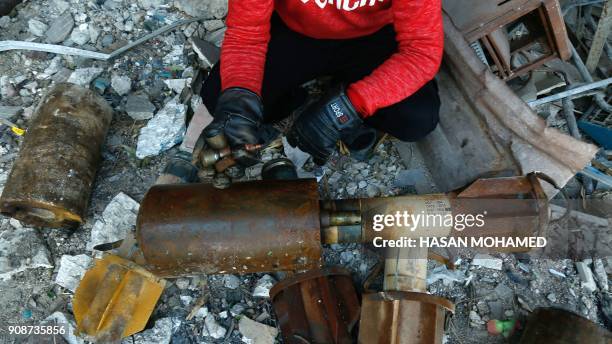 Syrian man shows remnants of rockets reportedly fired by regime forces on the rebel-held besieged town of Douma in the eastern Ghouta region on the...