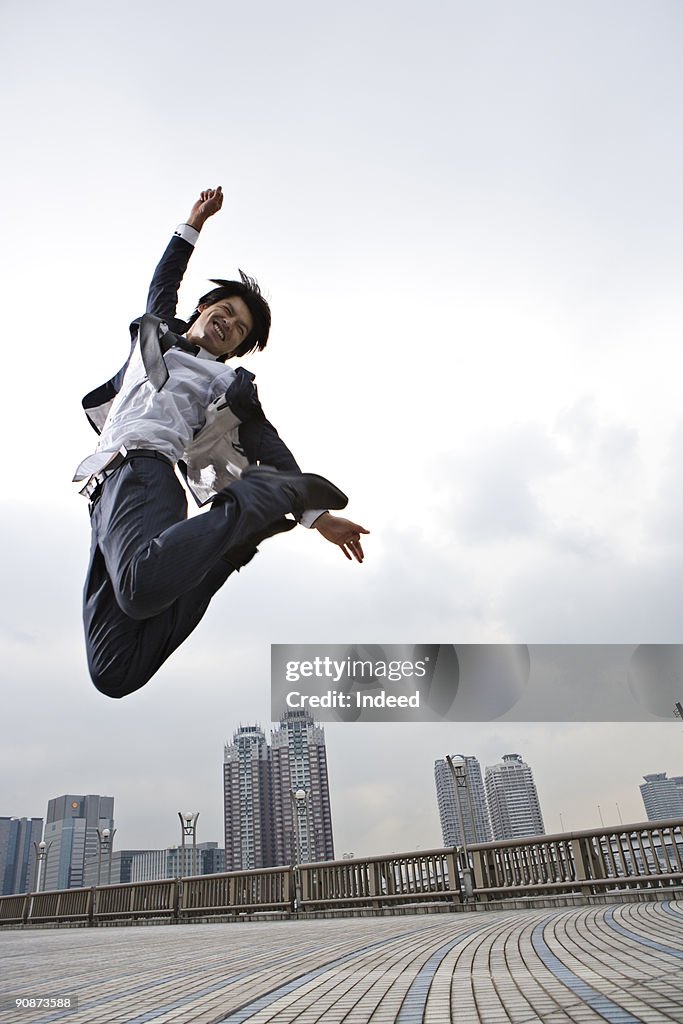 Businessman jumping, smiling