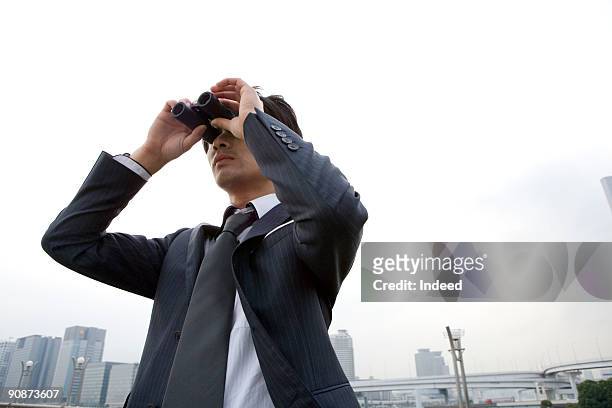 businessman looking through binoculers - spy glass businessman stock pictures, royalty-free photos & images