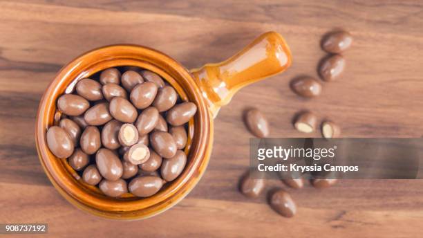 chocolate-coated almonds in glass bowl - amendoim noz - fotografias e filmes do acervo