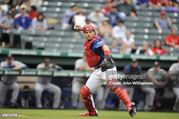 Catcher Ivan Rodriguez of the Texas Rangers fields his position as he throws to first base after fielding a ball hit out in front of home plate...