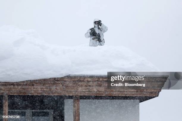 An armed member of the Swiss Police watches from the roof of the Hotel Davos ahead of the World Economic Forum in Davos, Switzerland, on Monday, Jan....