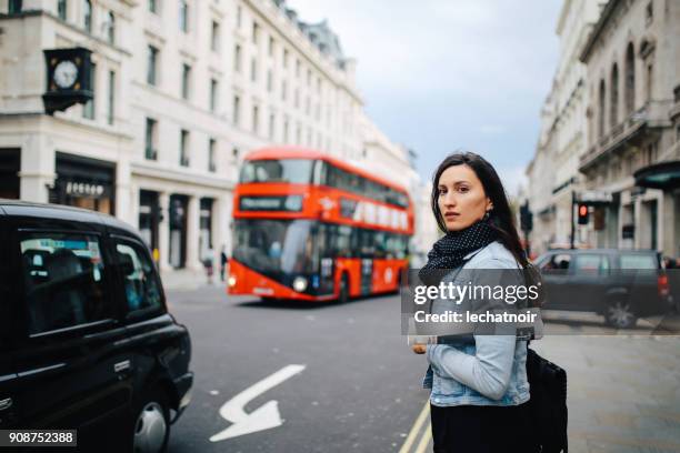 junge frau zu fuß auf den straßen von london - oxford street london stock-fotos und bilder