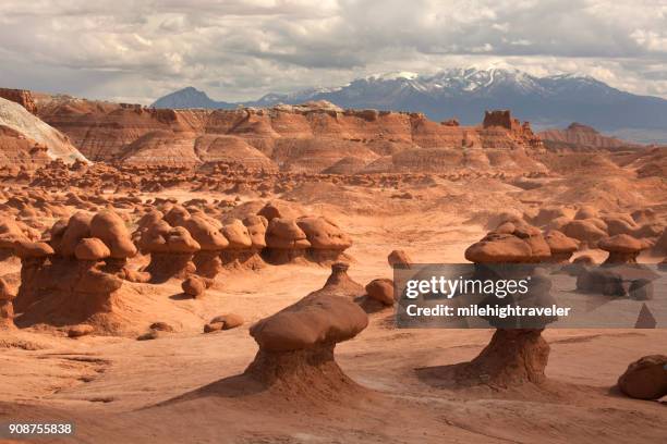 stone mushrooms goblin valley state park snow capped henry mountains utah - utah state stock pictures, royalty-free photos & images