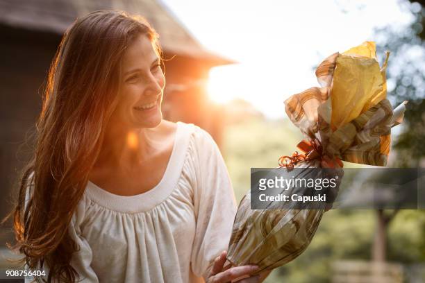 a woman giving an easter egg - chocolate happy stock pictures, royalty-free photos & images