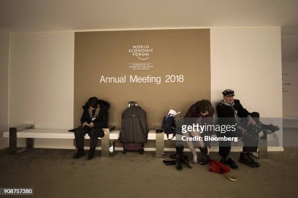 Attendees remove their wet footwear after arriving in the Congress Center ahead of the World Economic Forum in Davos, Switzerland, on Monday, Jan....