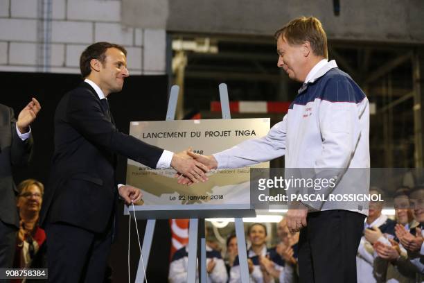French President Emmanuel Macron shakes hands with Didier Leroy, Executive Vice President of Toyota Motor Corporation, after he unveiled a plaque...