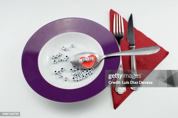 view of alphabet soup letters spelling love - alphabet soup stock pictures, royalty-free photos & images