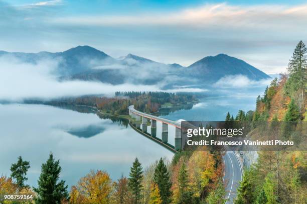 sylvenstein lake and bridge surrounded by the morning mist. bad tölz-wolfratshausen district, bavaria, germany. - alpen bayern fotografías e imágenes de stock
