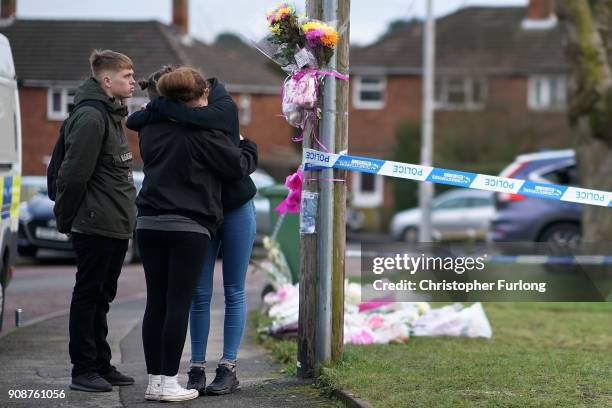 People react next to floral tributes outside a home in Valley View, Brownhills, Walsall, where Mylee Billingham, aged eight, was stabbed and later...