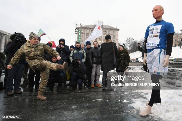 Ukrainian serviceman kicks a ball at a mannequin depicting Russian President Vladimir Putin dressed in a football uniform, during the "Stop Putin....