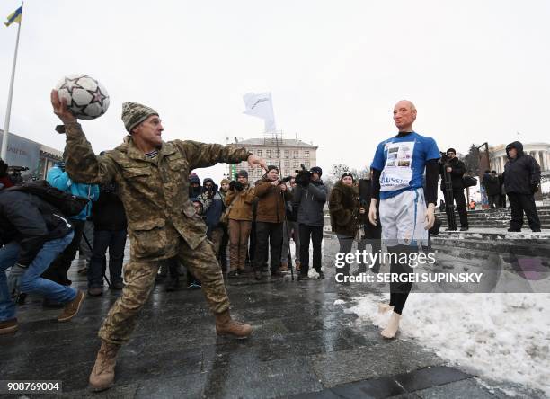 Ukrainian serviceman throws a ball at a mannequin depicting Russian President Vladimir Putin dressed in a football uniform, during the "Stop Putin....