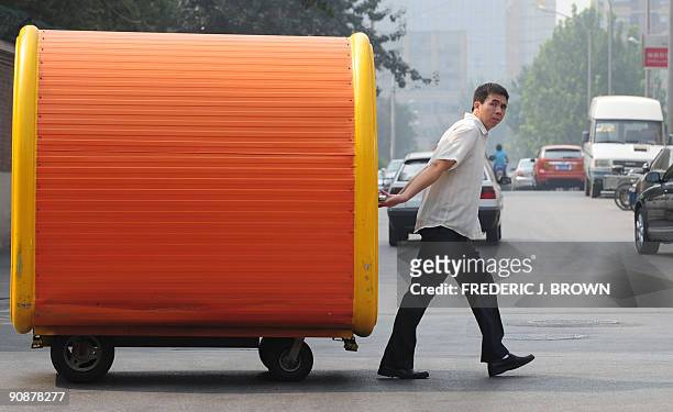 Man pulls a portable fast-food station along a street in Beijing on September 17, 2009. Often noted as a major success of the ruling communist party...
