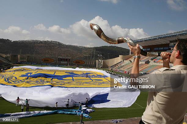 Man blows a Shofar as the largest flag in the world, the Jerusalem Flag, recognized by Guinness World Records, is being unfurled at the Teddy...