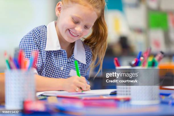 schoolgirl working at a desk. - back to school stock pictures, royalty-free photos & images